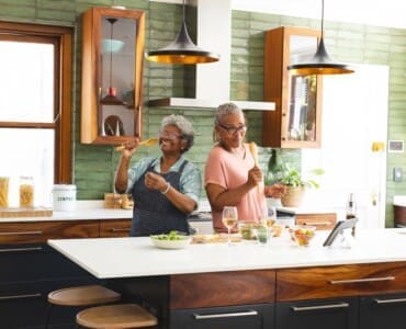 Older adults preparing a meal together in a home setting, representing independence, daily function, and quality of life supported through clinical excellence.